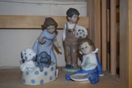 GROUP OF LLADRO FIGURES INCLUDING A BOY AND A GIRL AND TWO PUPPIES IN A BASKET