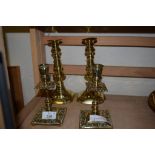 TWO PAIRS OF BRASS CANDLESTICKS