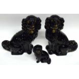 Three Staffordshire spaniels, all black painted with gold decoration, the largest 32cm high