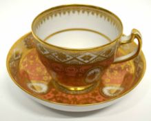 Early 19th century Coalport cup and saucer with a gilt design on salmon ground, pattern number