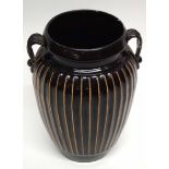 Chinese pottery Cizhou vase of ribbed form on a dark brown ground, with two loop handles, 23cm high