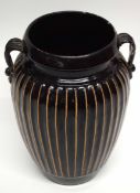 Chinese pottery Cizhou vase of ribbed form on a dark brown ground, with two loop handles, 23cm high