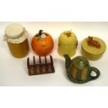 Group of butter tubs, jam jars and covers, one shaped as an orange, another jar and cover with