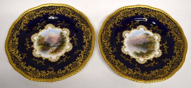 Pair of late 19th century Coalport plates, the blue ground with central cartouche with a landscape