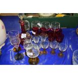 GLASS WARES INCLUDING A CRANBERRY COLOURED DECANTER AND SIX CRANBERRY COLOURED GLASSES