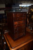 Small mahogany specimen type cabinet fitted with seven drawers on a plinth base^ 31cm wide