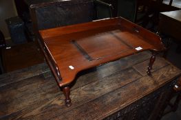 Vintage mahogany bed table^ central adjustable reading slope and gallery surround on short moulded