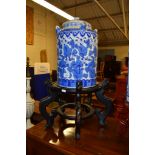 CHINESE CYLINDRICAL JAR AND COVER DECORATED IN BLUE WITH FOLIAGE AND FRUIT ON WOODEN STAND, 27CM