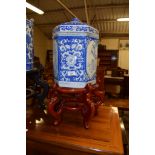LARGE ORIENTAL OCTAGONAL JAR AND COVER WITH BLUE AND WHITE DESIGN ON WOODEN STAND