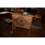 Oak sewing or work box of rectangular form^ lifting lid and carved front on trestle supports in