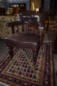 Late 19th century mahogany framed desk tub chair^ upholstered in brown leather button back raised on