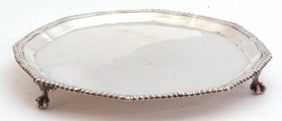 George V silver card salver of shaped circular form, with gadrooned rim syanding on three paw feet