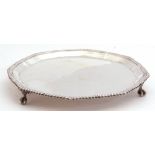 George V silver card salver of shaped circular form, with gadrooned rim syanding on three paw feet