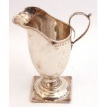 Victorian silver helmet shaped cream jug, plain polished design, capped scroll handle on a square