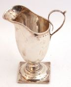 Victorian silver helmet shaped cream jug, plain polished design, capped scroll handle on a square