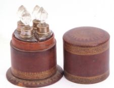 Early 20th century cylindrical leather cased set of four quadrant scent bottles with nickel