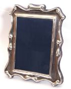 Elizabeth II silver photograph frame of rectangular form with scroll decorated edges, easel back,