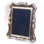 Elizabeth II silver photograph frame of rectangular form with scroll decorated edges, easel back,