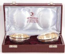 Mid-20th century cased pair of Indian silver circular small bowls embossed with foliate designs, 9cm