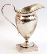 George V silver helmet shaped cream jug, reeded rim edge, plain loop handle on a square foot,