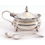 Hallmarked silver mustard of oval shape, the hinged lid with urn finial, blue glass liner,