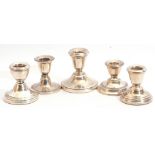 Group of five small 20th century hallmarked silver encased dressing table candlesticks of circular