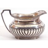 Edward VII silver cream jug of oval form, half fluted piped body and gadrooned lip with angular