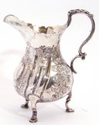 Late Victorian embossed pear-shaped cream jug in George II style, having card cut rim, leaf capped