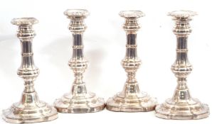 Set of four Regency period Sheffield plated candlesticks having shaped square loaded bases,