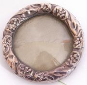 Small Edwardian circular embossed silver mounted photograph frame with convex glass, the green