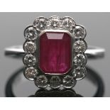 18ct white gold, ruby and diamond cluster ring, the rectangular cushion cut ruby bezel set and