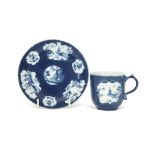 Rare Lowestoft porcelain cup and saucer, the blue ground with reserves of chinoiserie scenes to both