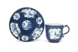 Rare Lowestoft porcelain cup and saucer, the blue ground with reserves of chinoiserie scenes to both