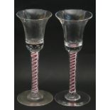 Pair of colour twist wine glasses, the bell bowls above multi series twist stems with Ruby