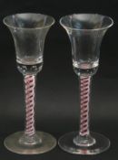 Pair of colour twist wine glasses, the bell bowls above multi series twist stems with Ruby