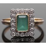 Emerald and diamond cluster ring, the rectangular step cut emerald bezel set and millegrained edged,