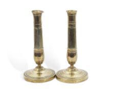 Pair of Regency period engraved brass candlesticks with circular bases, baluster and fluted columns,