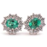 Pair of emerald and diamond cluster earrings featuring an oval emerald, 1.15ct total, each within
