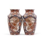 Pair of Japanese porcelain vases with Imari type design in panels with flowers on a blue ground,