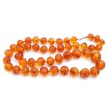 Vintage amber bead necklace, a single row of graduated slightly mis-shapen circular beads, 33cm