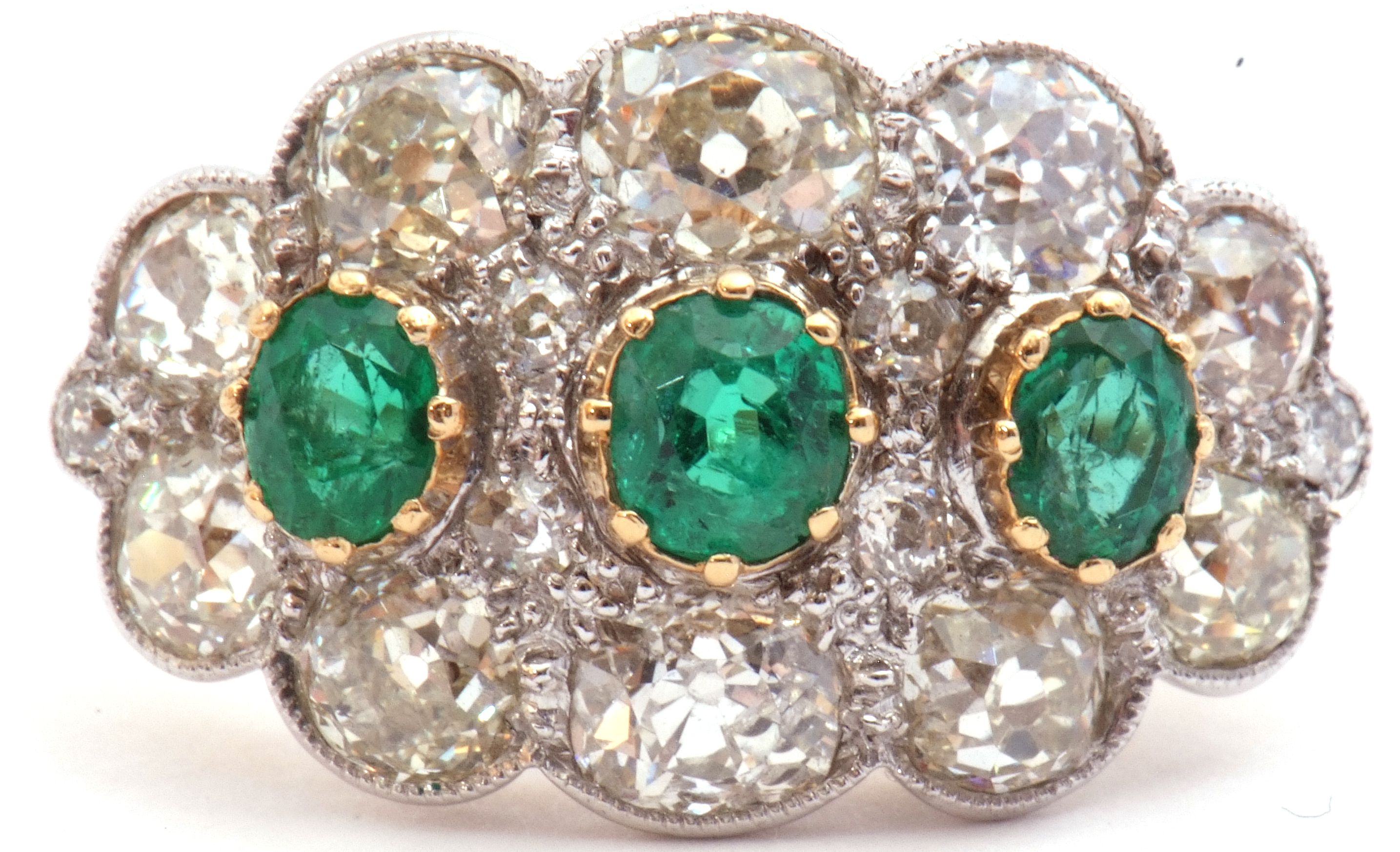 Large emerald and diamond cluster ring of oval design, featuring three graduated oval faceted