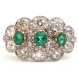 Large emerald and diamond cluster ring of oval design, featuring three graduated oval faceted