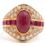 18ct gold ruby and diamond cluster ring, the oval shaped panel centring a cabochon ruby, flanked