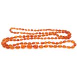 Edwardian long graduated cognac amber bead necklace, a single row of oval shaped faceted beads, 24mm
