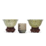 Two spinach green jade small bowls on wooden bases, together with a further small jade cup (3)