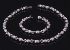18ct white gold bracelet, a design of burnished oval beads and plain polished links, 18.5cm long,