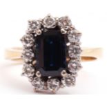 Precious metal sapphire and diamond cluster ring, the rectangular cut sapphire set within a border