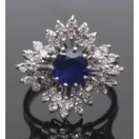 Sapphire and diamond cluster ring, a snowflake design centring a round cut faceted sapphire (7mm