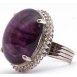 Large amethyst and diamond dress ring, the large oval shaped cabochon 24mm x 24mm, four claw set and