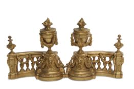 Pair of 19th century gilded andirons, crested with swag and urn capitals and the bases applied